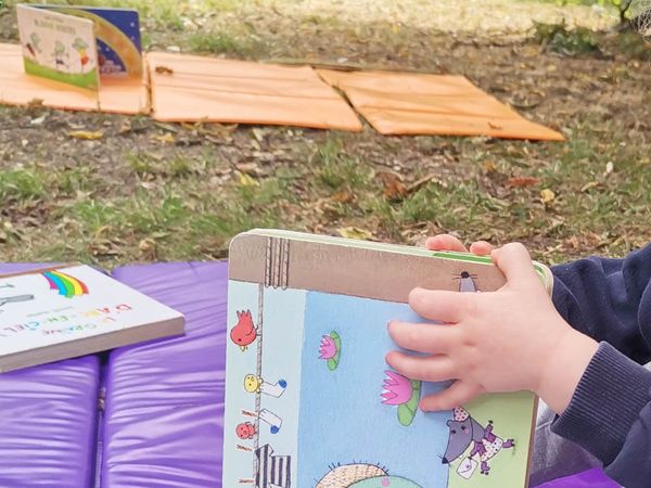 Enfant manipulant un livre pour découvrir les images et les mots